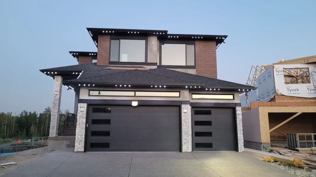 Modern Calgary home by day with permanent lighting off — the roofline channel blends into the soffit