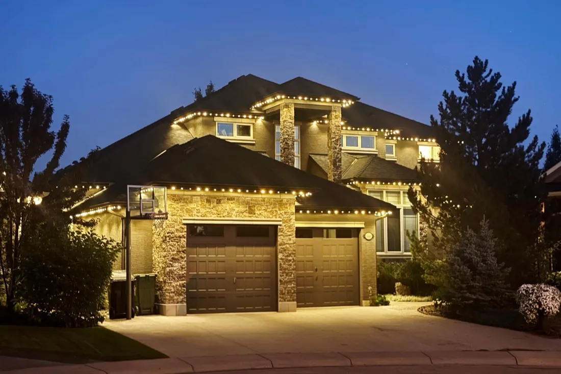 Two-storey Calgary home outlined in warm white permanent LED trim lighting at night