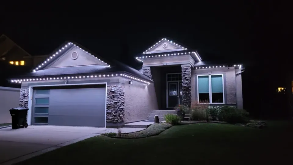 Calgary bungalow at night with warm white permanent LED lights outlining the roof peaks and garage