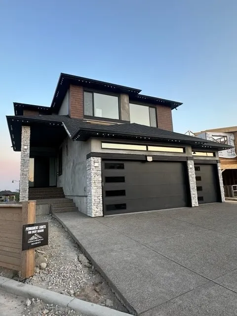 Modern Calgary two-storey at dusk with permanent LED channels installed along the rooflines, unlit and virtually invisible before dark