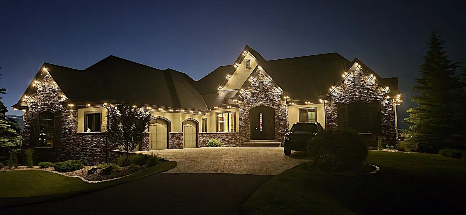 Acreage lighting Calgary — permanent LED trim lighting the long roofline and wide frontage of an estate home at night